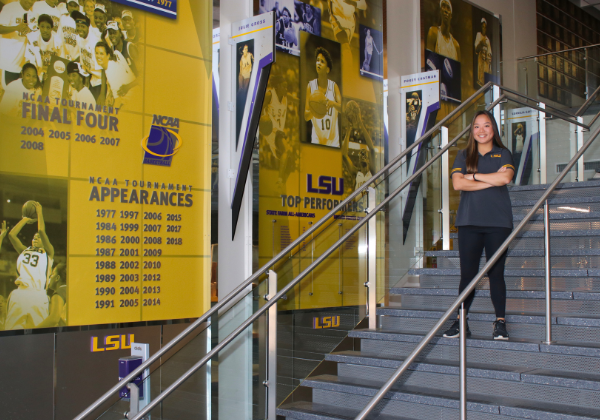 Sport Administration student on stairs at basketball arena.