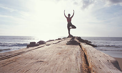 photo by Marion Michele woman doing yoga outside by the beach